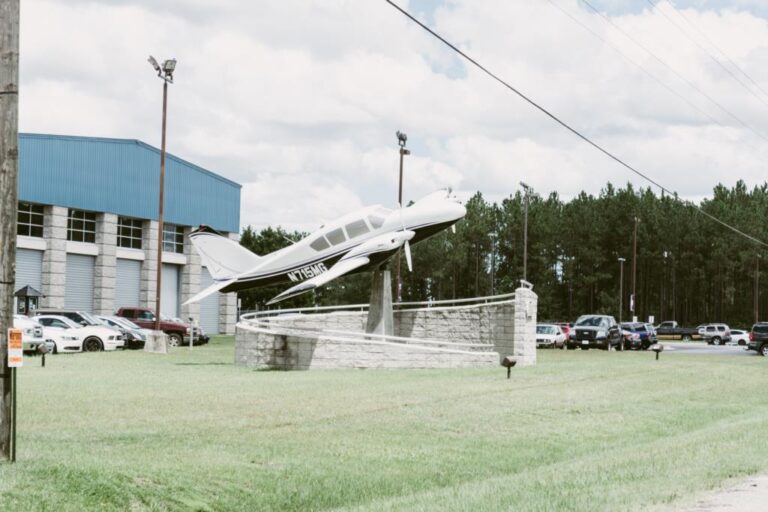 A small propeller aircraft mounted on a pedestal outside the Eastman aviation campus